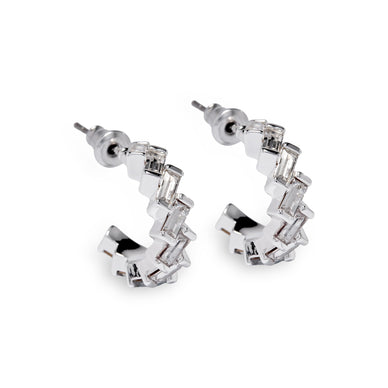 Discover a new twist on timeless elegance with our Zigzag Eternity Hoop Earrings, an updated version of our beloved small gem eternity hoops. These earrings combine the same lightweight comfort and classic size with a modern zigzag design, ensuring you stand out with every wear. Silver over Brass available in Crystal, Blue & Green. 16mm Hoop Fulfilled by our friends at Short & Suite *Please Note: Rewards cannot be applied to this product This item is not eligible for returns This item cannot be shipped outside the U.S.