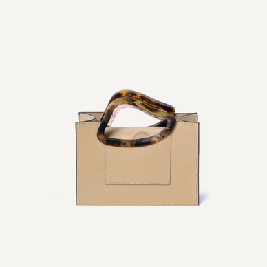 The mini bag version of Arp’s Sailent is combines vintage elegance, modernity and sophistication with a minimal clean cut. It's organic shaped resin handles are indicative of Naturae Sacra’s signature design detailing. This un-conventional handles design has been crafted to allow ergonomic gripping. Design process of Arp’s Sailent took an inspration by Hans (jean) Arp’s ‘silence’ named abstract sculpture which is most simple but most compelling. DETAILS 13cm (H) x 19cm (W) x 10cm (D), Calf Leather Magnetic closures Natural resin casting handle Long cross-body strap Two accordion-like compartments Embossed NATURAE SACRA lettering at the front Two interior pouch pocket A card holding slit at the back Dust bag and branded box included PRODUCT CARE CALF LEATHER: Each leather hides unique characteristics such as texture and natural markings. Also, the most prominent feature of vegetal tanned leather is that it changes color with usage. Aging and tone variations should not be considered an imperfection as leather is a natural product. Please, avoid contact with water and any oil-based substances. RESIN HANDLES: Resin handles are handmade and each piece has a its uniqueness points, which means that there are not two alike pieces. For that reason, we cannot guarantee you will receive an item exactly identical to what is pictured. Colors and swirls shown are a guideline only. Resin is strong and durable and should be treated like a ceramic since it can break if dropped or knocked against a hard surface. Also, it does not show resistance to very high temperatures. Fulfilled by our friends at NATURAE SACRA *Please Note: Rewards cannot be applied to this product This item is not eligible for returns This item cannot be shipped outside the U.S.