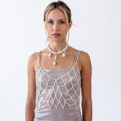 Pearls over diamonds - but only this once, we’ll allow pearls to be a girl’s best friend. Layer this over basics or strut this as a standalone piece. Embrace your inner seductress with this statement piece that speaks volumes without uttering a word. Our faux-pearl Dione piece is sure to turn necks as a pearl tank top. Non-adjustable.  
Founder's tip: gift this piece to a bride in your life. 
Size Guide 
Fulfilled by our friends at  Beverly Hills 

*Please Note: 

This item is not eligible for returns 
This item cannot be shipped outside the U.S.

  